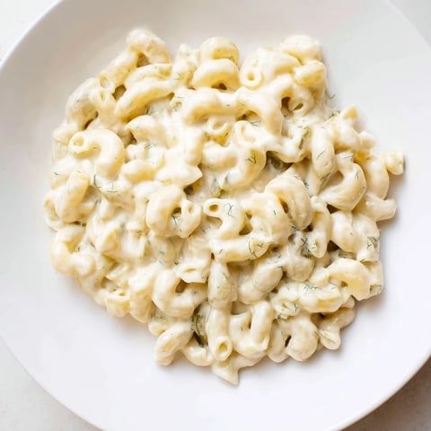 A tempting close-up of Pickle Mac and Cheese, creamy with a sprinkle of fresh dill.
