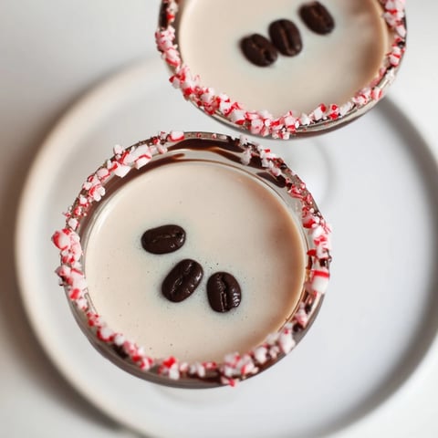 Creamy Peppermint Espresso Martini in a glass, rimmed with chocolate and crushed candy canes for festive flavor.