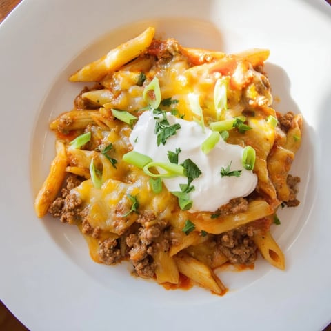 Close-up of Easy Beef Enchilada Pasta, bubbly cheese topping a savory ground beef and pasta mix.