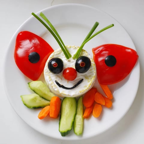 Detailed ladybug-themed Coccinelle Amusante Planche Pique-Nique platter with fresh veggies, dips, and baguette slices.