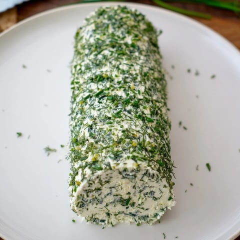 Herb-Coated Cheese Log with vibrant herbs and crackers, ready for a delicious American appetizer.