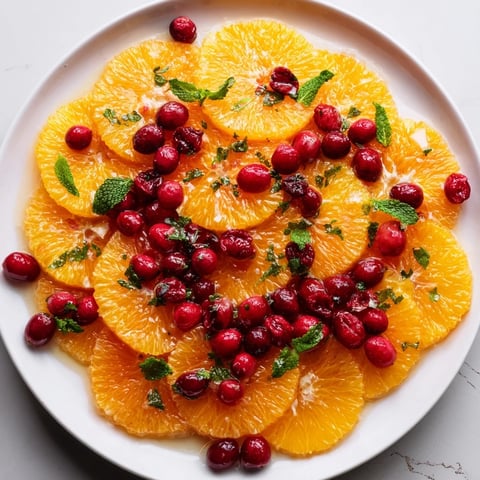 Vibrant winter fruit salad with orange slices and cranberries, a refreshing side dish ready in minutes.