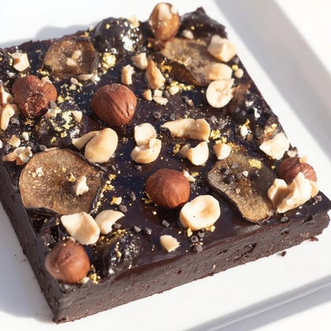 A close-up of The Midnight Mosaic shows a decadent slice with figs and olives.