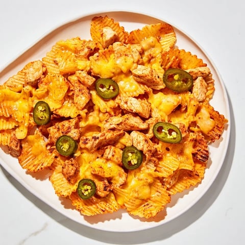 Air-fried Pasta Chip Nachos: Crispy pasta chips topped with savory taco chicken, melted cheese, and fresh jalapeños.