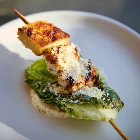Grilled chicken caesar salad skewers, ready to enjoy with vibrant romaine and creamy Caesar dressing.