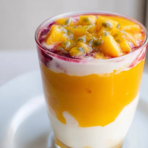 Tropical Sunset Smoothie layered to perfection, showcasing mango, passion fruit, and orange hues.