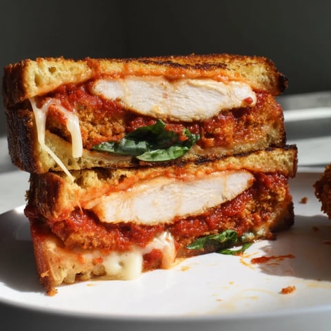 Golden Chicken Parm Grilled Cheese with melted mozzarella and crispy, fried chicken slices.