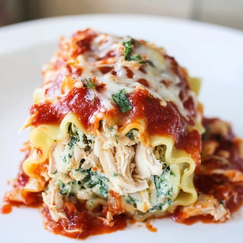 Chicken and Spinach Lasagna Rolls bubbling with melted mozzarella and marinara sauce create a delicious aroma.