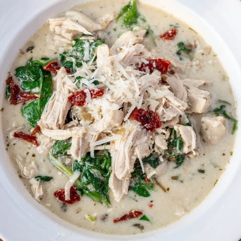 A creamy, comforting Creamy Tuscan Chicken Soup, garnished with Parmesan cheese ready to eat.