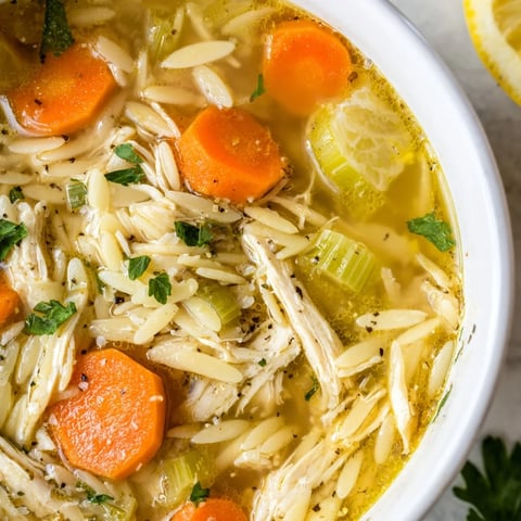 Steaming bowl of Lemon Pepper Chicken Orzo Soup: tender chicken and pasta in a flavorful broth.
