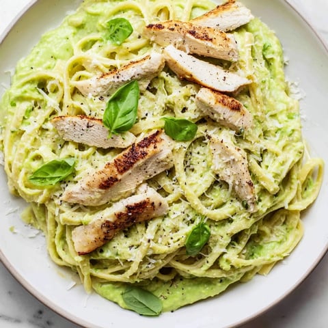 Creamy Avocado Chicken Pasta with grilled chicken slices bathed in a vibrant green, smooth sauce.