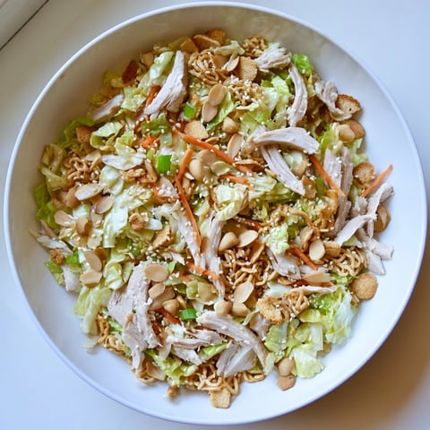 A colorful bowl of Crunchy Ramen Chicken Salad, a refreshing Asian-inspired potluck dish.