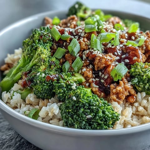 Sweet and Spicy Turkey Broccoli Bowl with tender ground turkey in a glossy glaze, steamed broccoli, and brown rice topped with green onions.