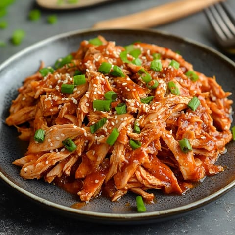 A plate of chicken with green onions.