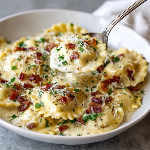 A bowl of pasta with cheese and bacon.