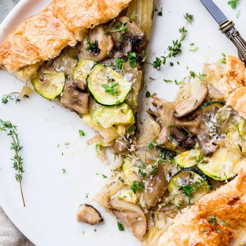 Rustic Garlic Parmesan Dinner Galette—A savory, vegetable-filled tart, ready for slicing.