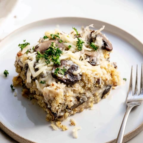 Close-up of the Alfredo Quinoa Mushroom Bake, revealing the cheesy top and tender quinoa.