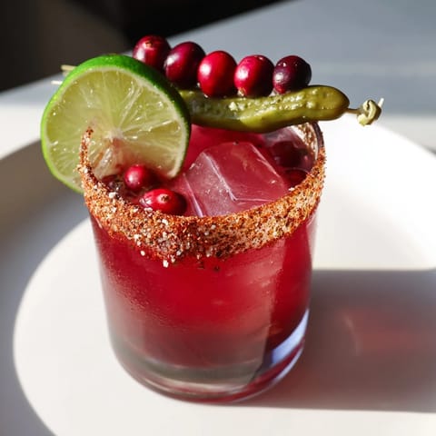 Bright red cranberry juice mixes with tequila in this zesty DIY cranberry-pickle margarita.