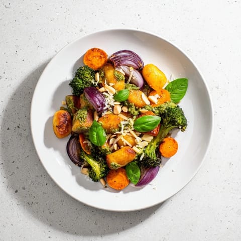 Aromatic Sheet Pan Pesto Gnocchi with caramelized sweet potatoes and Parmesan cheese for a colorful dinner.
