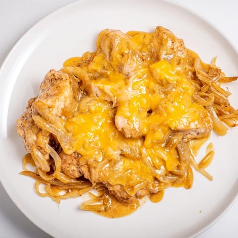 This Instant Pot French Onion Chicken recipe shows juicy chicken breasts in rich, caramelized onion gravy.