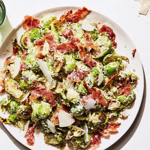 This warm Brussels Sprouts Caesar, topped with crunchy prosciutto, is a hearty, flavorful salad option for dinner.