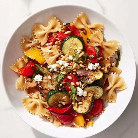 Beautifully arranged Festive Bow Tie Pasta Platter, featuring bright red and yellow bell peppers alongside fresh herbs.