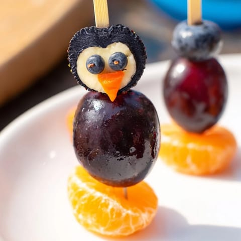 Freshly made Penguin Fruit Skewer Army, a playful and healthy snack featuring strawberry bellies.