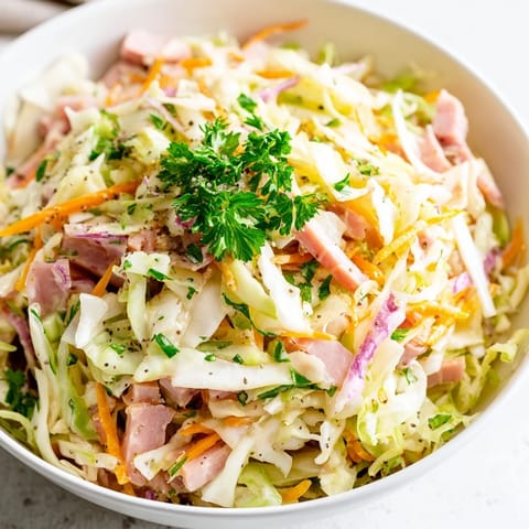 Perfectly balanced with sweet honey and sharp Dijon, this German Cabbage Coleslaw With Shredded Ham offers a hearty, crunchy bite for any meal.