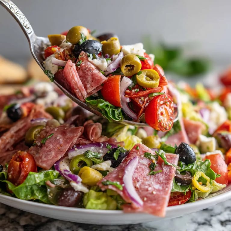 A stacked muffuletta salad on a plate.