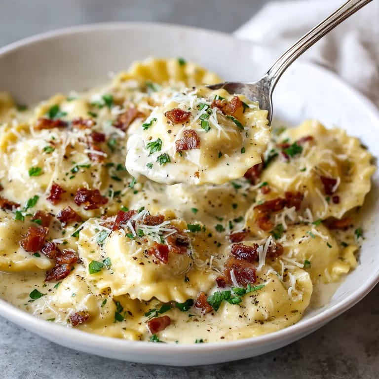 A bowl of pasta with cheese and bacon.