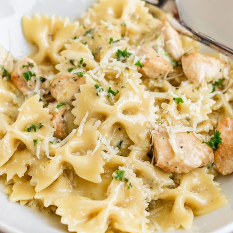 Savory Mozzarella Garlic Butter Chicken Bowties plated with pepper and herbs, a cozy meal.