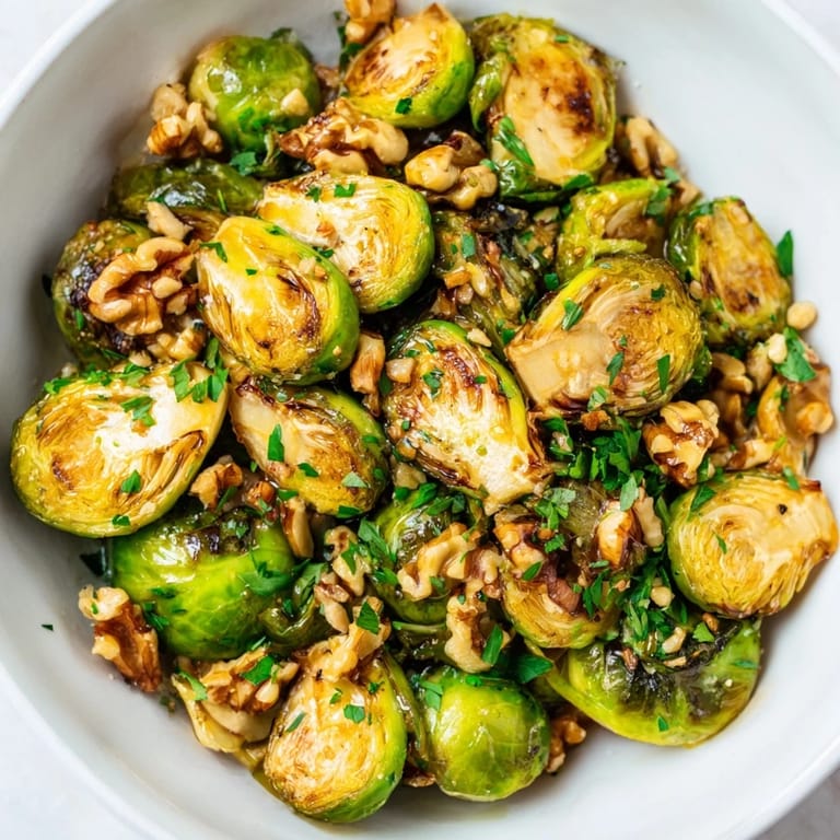 Savory maple glazed Brussels sprouts topped with crunchy walnuts, perfect for gatherings.