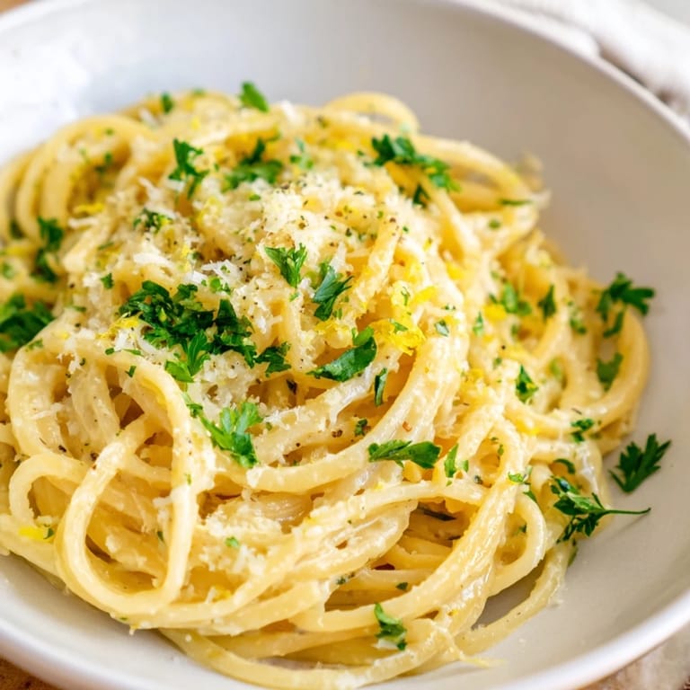 A beautiful bowl of Lemon-Garlic Greek Yogurt Pasta, with Parmesan cheese sprinkled on top for a delightful meal.
