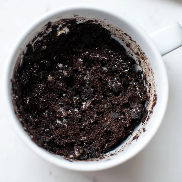 Steaming hot Oreo Mug Cake, a decadent dessert that's easy to make in your microwave.