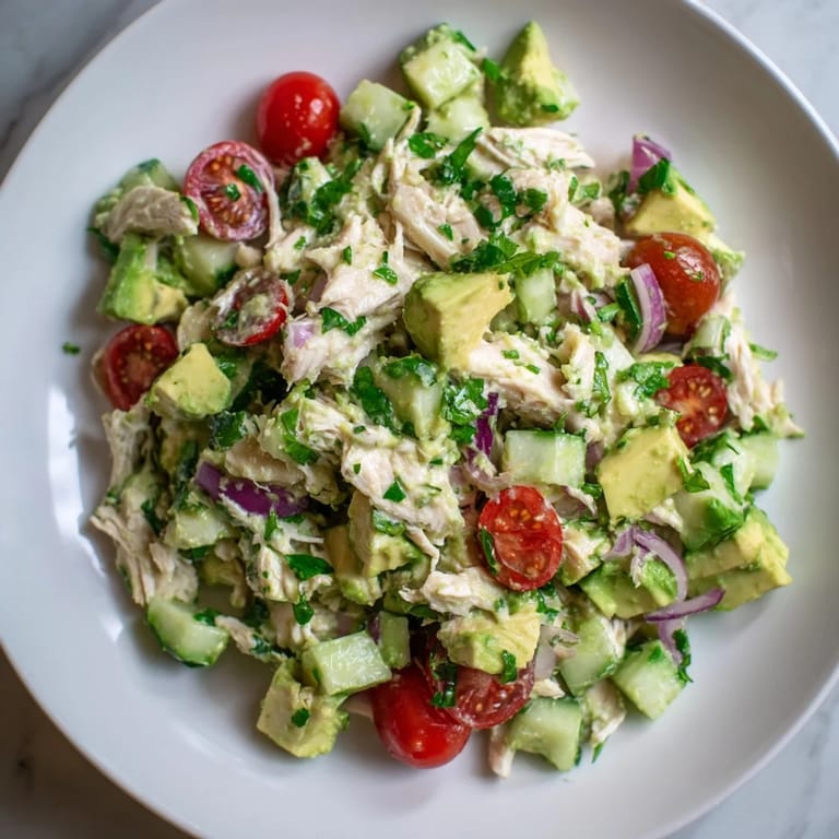 Tender chicken mingling with fresh herbs and avocado, creating a delicious avocado chicken salad ready to serve.