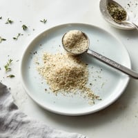 A white plate with a spoonful of homemade garlic parmesan seasoning.