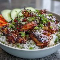 Tender glazed chicken atop fluffy rice with crisp veggies in a Sticky Chicken Rice Bowl.